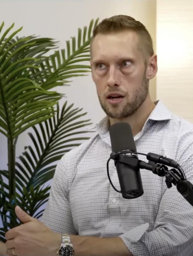 Andrew mid-conversation at a podcast mic